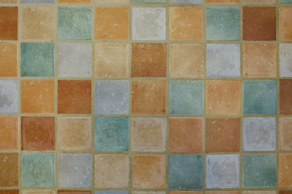 Carreaux carrés aux tons ocre, sable, vert d'eau et bleu gris, posés en damier irrégulier