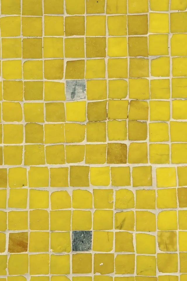Mur de petits carreaux émaillés jaune soleil, aux nuances irrégulières, joints clairs